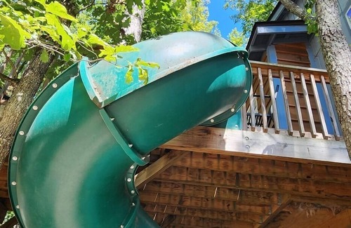 Mill Spring Cabina | 2-story treehouse with a cargo net connecting the upstairs lofts, a large balcony with a slide to the ground level, sleeps 10.