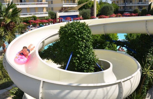 Bibione Condominio | Apartamento vacacional con un tobogán de agua y zona de la piscina
