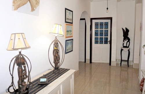 Serrekunda Cama Y Desayuno | Habitación doble con cama de matrimonio y sol de mañana en B & B Villa Calliandra