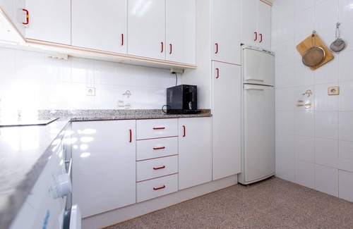 Los Puertos Apartamento | Enjoy a relaxing vacation by the sea in this vacation apartment with a beautiful conservatory.