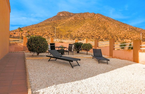 Los Puertos Apartamento | Enjoy a relaxing vacation by the sea in this vacation apartment with a beautiful conservatory.