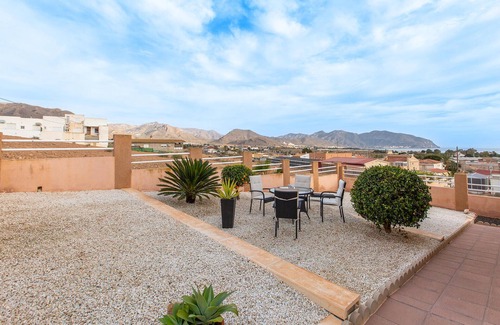 Los Puertos Apartamento | Enjoy a relaxing vacation by the sea in this vacation apartment with a beautiful conservatory.