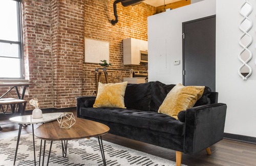 Kansas City Apartamento | Exposed brick, wood beams, & chic touches give this loft serious style. Enjoy skyline views from the rooftop, a full kitchen with coffee bar, king bed, on-site gym, & quick access to the free KC streetcar. Walk to shops/dining, and the City Market!