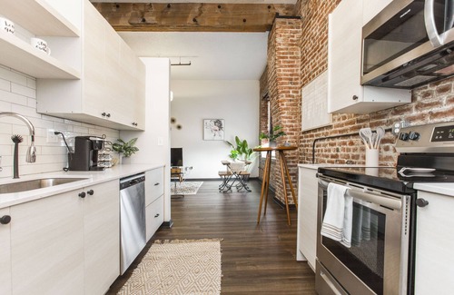 Kansas City Apartamento | Exposed brick, wood beams, & chic touches give this loft serious style. Enjoy skyline views from the rooftop, a full kitchen with coffee bar, king bed, on-site gym, & quick access to the free KC streetcar. Walk to shops/dining, and the City Market!