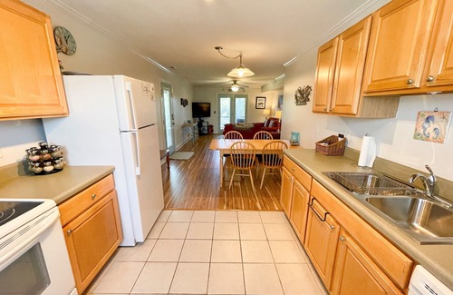 Ocracoke Condominio | Relajarse y ver la palabra pasar desde este apartamento del segundo piso con vistas a un gran patio.