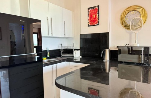 Village Road Apartamento | G.3.11 Red Seafront apartment. Restaurant on beach, lounge chairs, umbrellas