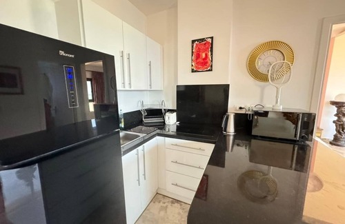 Village Road Apartamento | G.3.11 Red Seafront apartment. Restaurant on beach, lounge chairs, umbrellas