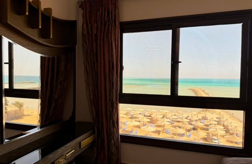 Village Road Apartamento | G.3.11 Red Seafront apartment. Restaurant on beach, lounge chairs, umbrellas