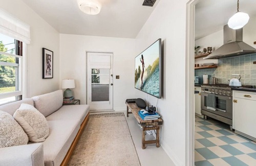 West Beach Apartamento | Library Suite – The Marlowe Seaside Inn: Spacious one-bedroom suite in Santa Barbara featuring a sunny writing sunroom, private balcony, and vintage decor.