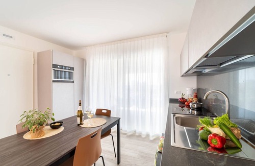 Lignano Sabbiadoro Apartamento | Apartamento moderno con solárium y vista panorámica a la laguna y al mar.