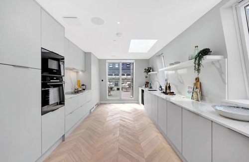 Fitzrovia Condominio | Soak in the Spalike Marble Bath at Plush Penthouse
