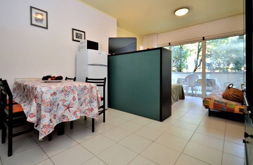 Bibione Pineda Apartamento | Elegante estudio en un edificio rodeado de un paisaje verde.