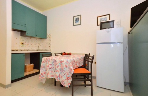 Bibione Pineda Apartamento | Elegante estudio en un edificio rodeado de un paisaje verde.