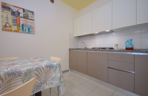 Bibione Pineda Apartamento | Elegante estudio en un edificio rodeado de un paisaje verde.