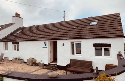 Bryngwran Casa | Whitewashed 1 bedroom stone cottage, with king size 4 poster bed. Pet friendly.