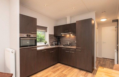 Lieren Casa | Zand Lodge is a charming chalet for 6 people in the Veluwe, featuring a warm wooden interior, a fully equipped kitchen, and a covered terrace.