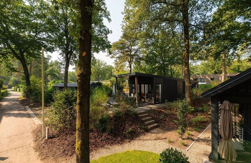 Lieren Casa | Zand Lodge is a charming chalet for 6 people in the Veluwe, featuring a warm wooden interior, a fully equipped kitchen, and a covered terrace.