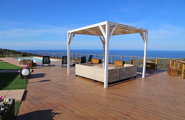 Villa luminosa con piscina privada, rodeada de césped y vistas al mar