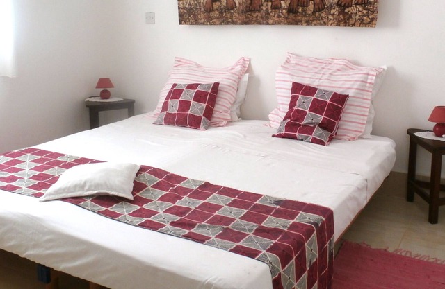 Habitación doble con cama de matrimonio y sol de mañana en B & B Villa Calliandra