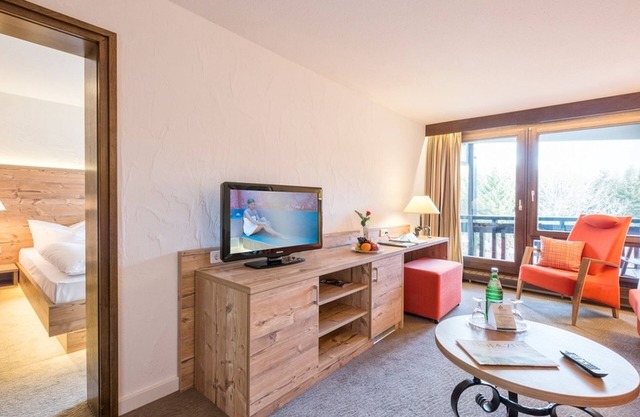 Suite clásica junto al bosque con cama doble, sala de estar independiente y terraza o balcón.