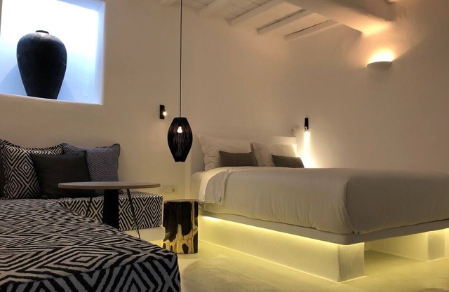 Mykonian Mews H1 Luxury Cave Suite con jacuzzi al aire libre, salón y cocina.
