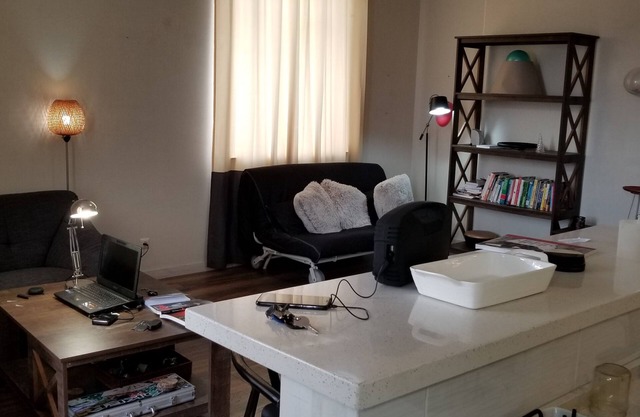 Estudio recientemente renovado de un dormitorio con todos los muebles y cocina.