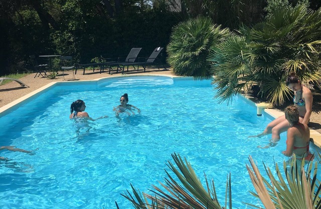 Villa provenzal con grandes pinos y piscina.