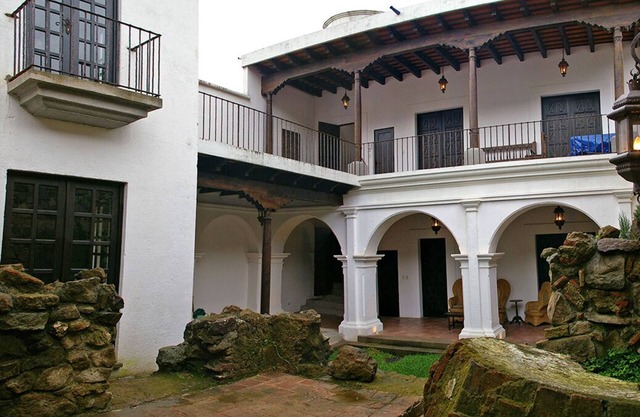 Romántica casa colonial con chimenea y terraza.