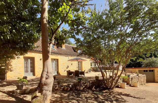 Stone farmhouse surrounded by woodland