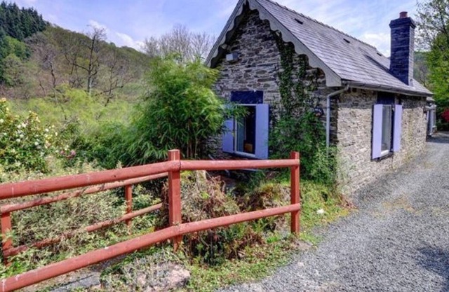 Esta atractiva casa de piedra se encuentra sobre el río Dulas, rodeada por las colinas boscosas del