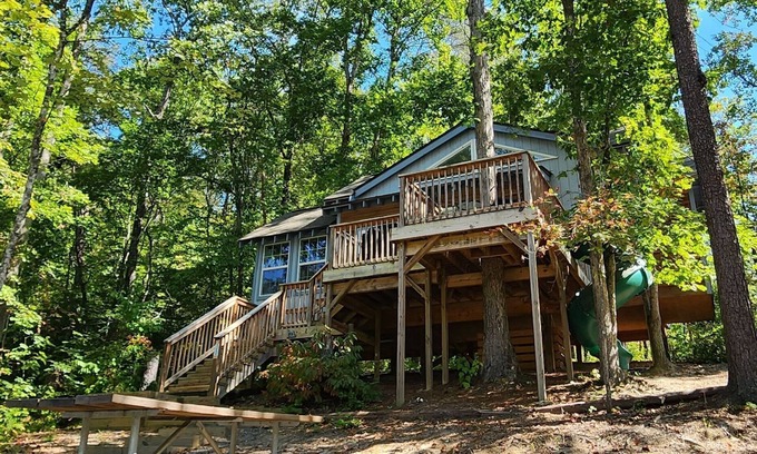Mill Spring Cabina | 2-story treehouse with a cargo net connecting the upstairs lofts, a large balcony with a slide to the ground level, sleeps 10.