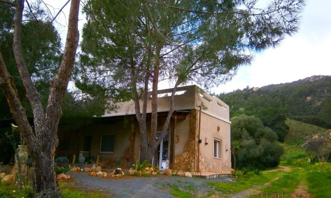 Santa Margherita di Pula Villa | Villa individual independiente rodeada de vegetación con horizonte sobre el mar