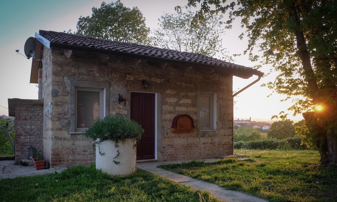 San Maurizio Casa | Dependance Rose, una sala de estar romántica con cama doble y baño.
