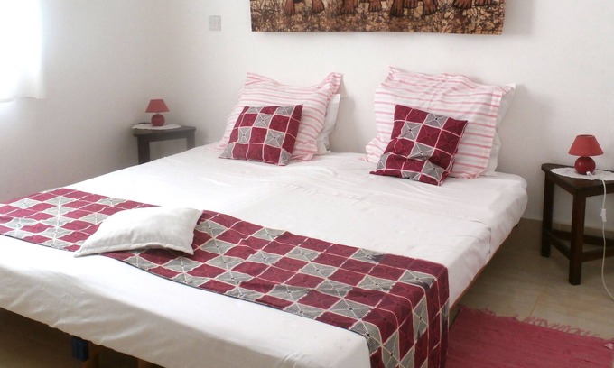 Serrekunda Cama Y Desayuno | Habitación doble con cama de matrimonio y sol de mañana en B & B Villa Calliandra