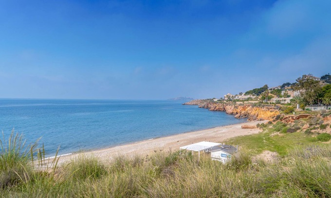 Los Puertos Apartamento | Enjoy a relaxing vacation by the sea in this vacation apartment with a beautiful conservatory.