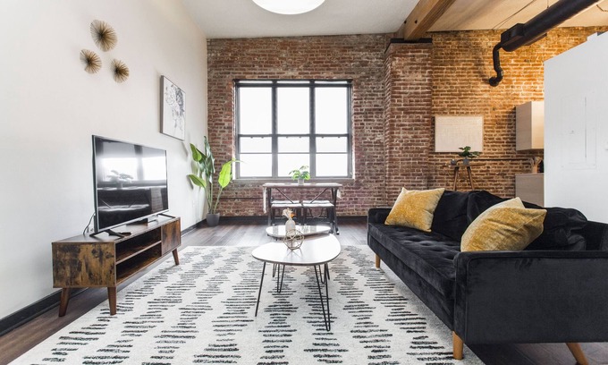Kansas City Apartamento | Exposed brick, wood beams, & chic touches give this loft serious style. Enjoy skyline views from the rooftop, a full kitchen with coffee bar, king bed, on-site gym, & quick access to the free KC streetcar. Walk to shops/dining, and the City Market!