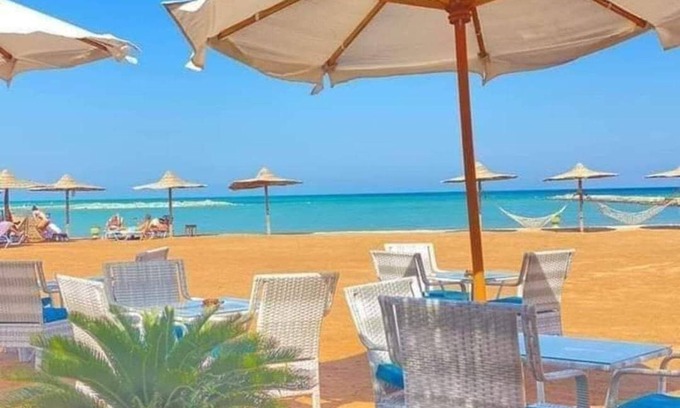 Village Road Apartamento | G.3.11 Red Seafront apartment. Restaurant on beach, lounge chairs, umbrellas