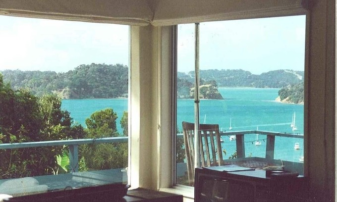 Mahurangi West Cabaña | Casa de playa icónica de Nueva Zelanda con vistas al puerto y arbustos elevados.