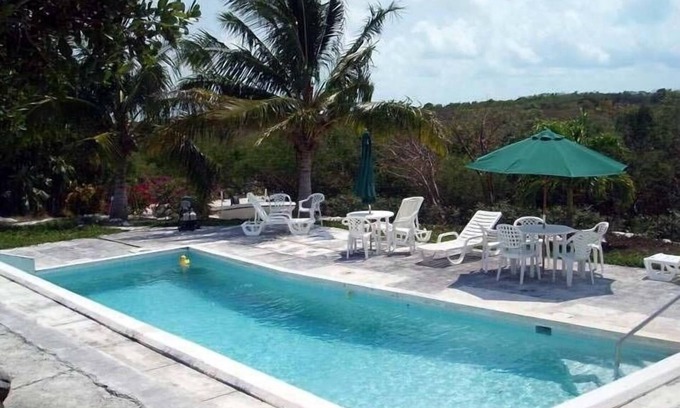 Hartswell Cabaña | Exuma Vacation Cottages en la cima de la colina con acceso frontal al agua, muelle y kayaks.
