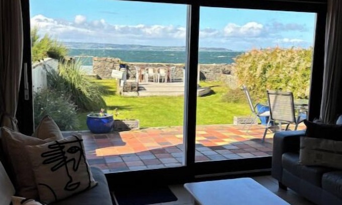 Bangor Cabaña | Splash Cottage Beach house with sea touching back garden