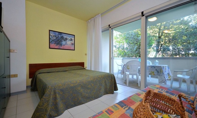 Bibione Pineda Apartamento | Elegante estudio en un edificio rodeado de un paisaje verde.