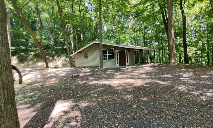 Darlington Casa | The Chalet is located in the woods of a gated property with a covered porch.