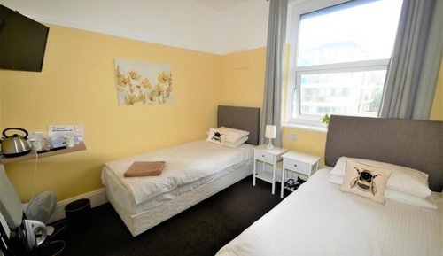 Habitación básica con 2 camas individuales, baño compartido, vistas a la ciudad