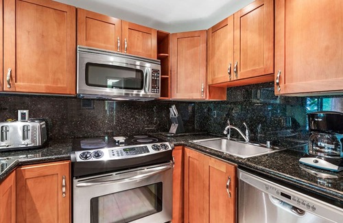 Kaanapali Condominio | Maui Resort Rentals: The Whaler 124 - Esquina de lujo en la planta baja 1BR / 2BA con balcón envolvente, vista parcial al océano y al oeste de la montaña de Maui, amplia área de césped adyacente
