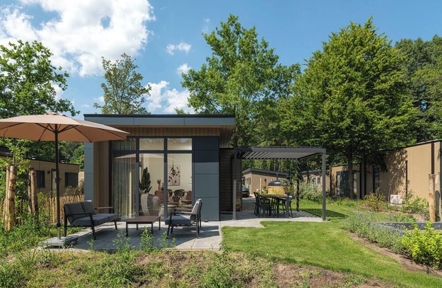 Enjoy a luxurious holiday home for 4 people in the wooded nature of the Veluwe, complete with modern amenities, air conditioning, and a stylish pergola for optimal comfort. Additionally, unwind in the private hot tub, perfect for relaxing after a day
